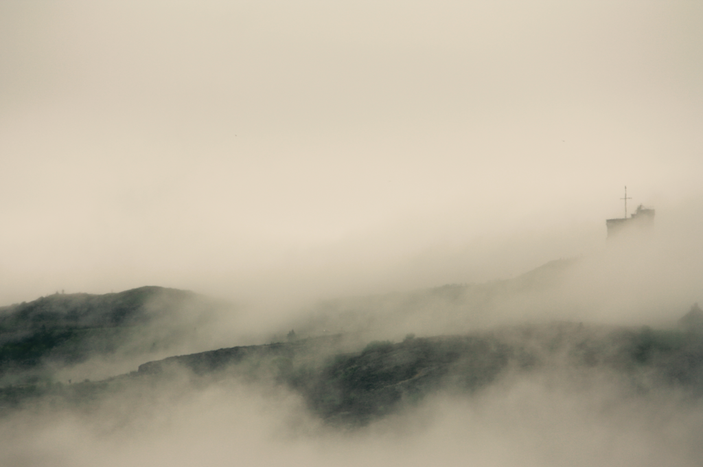 Black and white photograph of heavy fog over hills with the signal hill station nearly entirely obscured 